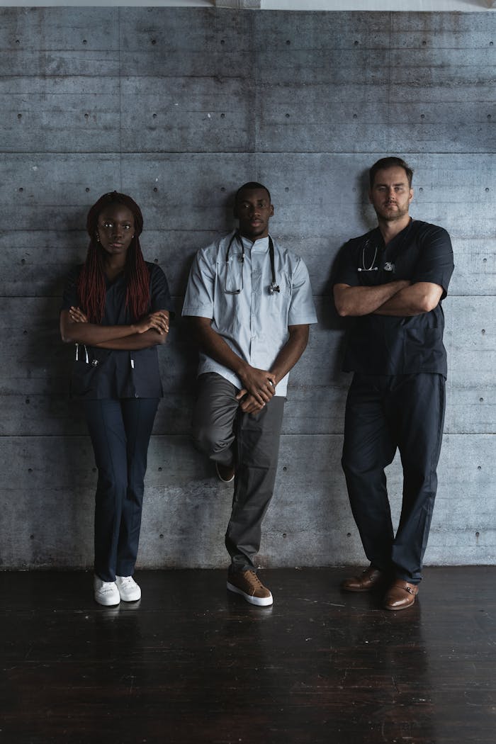 Three diverse healthcare professionals confidently posing in a modern indoor setting.