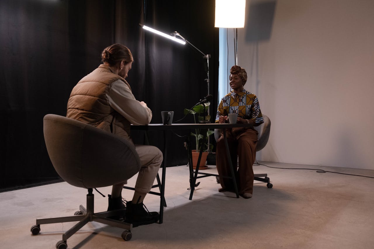about-us A man and woman recording a podcast in a professional studio environment.